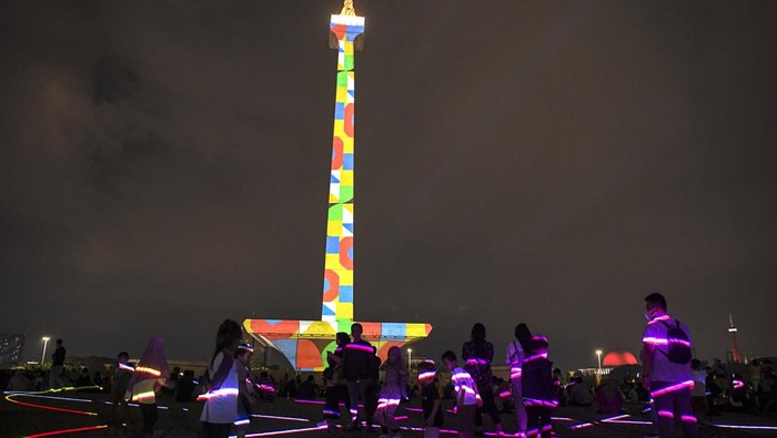 Pengunjung menyaksikan pertunjukan video mapping di Monumen Nasional (Monas), Jakarta, Senin (24/4/2023). Pemprov DKI mengadakan pagelaran Monas Week dan Pentas Seni Monas dengan menampilkan berbagai macam pertunjukan diantaranya air mancur menari, video mapping, dan penampilan musik sebagai bentuk hiburan masyarakat pada libur Lebaran. ANTARA FOTO/M Risyal Hidayat/aww.