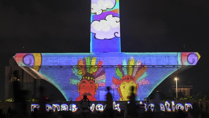 Pengunjung menyaksikan pertunjukan video mapping di Monumen Nasional (Monas), Jakarta, Senin (24/4/2023). Pemprov DKI mengadakan pagelaran Monas Week dan Pentas Seni Monas dengan menampilkan berbagai macam pertunjukan diantaranya air mancur menari, video mapping, dan penampilan musik sebagai bentuk hiburan masyarakat pada libur Lebaran. ANTARA FOTO/M Risyal Hidayat/aww.