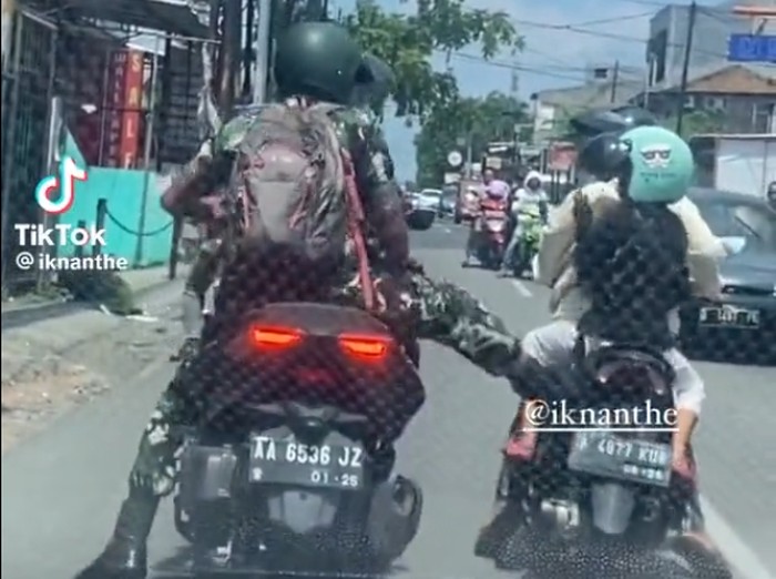 Oknum TNI berinisial Praka ANG diproses hukum usai menendang ibu-ibu yang memboncengi anaknya di jalanan Bekasi. Praka ANG diberi sanksi disiplin dan ditahan. (Tangkapan layar video viral)