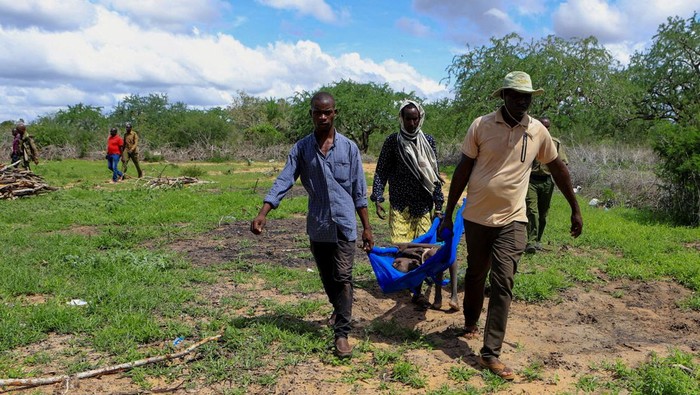 Kenya police officers and civilians rescue an emaciated member of a Christian cult named as Good News International Church, whose members believed they would go to heaven if they starved themselves to death, in Shakahola forest of Kilifi county, Kenya April 24, 2023. REUTERS/Stringer REFILE - QUALITY REPEAT