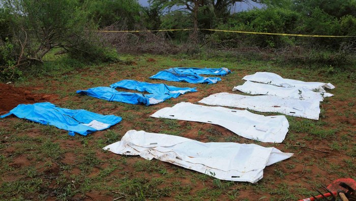 Kenya police officers and civilians rescue an emaciated member of a Christian cult named as Good News International Church, whose members believed they would go to heaven if they starved themselves to death, in Shakahola forest of Kilifi county, Kenya April 24, 2023. REUTERS/Stringer REFILE - QUALITY REPEAT