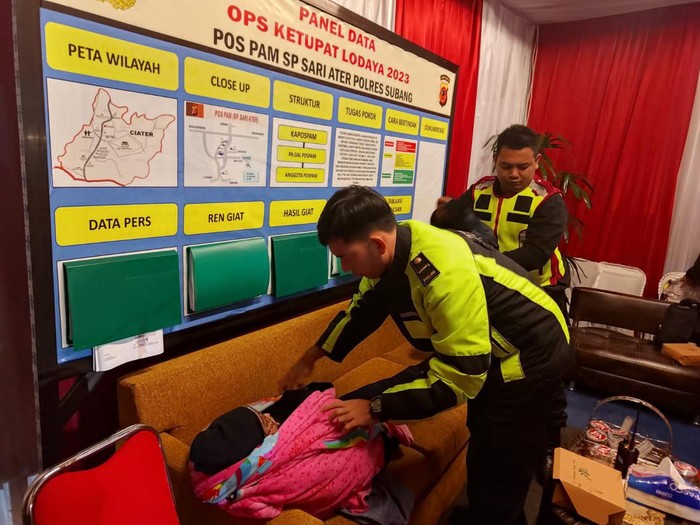Polisi saat mengevakuasi wisatawan yang pingsan karena kedinginan