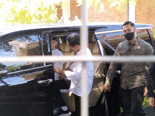 Presiden Jokowi dan cucu pertamaya Jan Ethes mengambil kaos dalam mobil untuk dibagikan kepada warga Labuan Bajo di BNN pelataran Puncak Waringin, Selasa (25/4/2023). (Ambrosius Ardin)