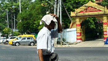 Seorang pria menutupi kepalanya dengan handuk untuk berlindung dari sinar matahari selama gelombang panas menimpa Yangon, Myanmar, beberapa hari silam. Monster gelombang panas yang tidak seperti sebelumnya, demikian cuitan dari pakar klimatologi Maximiliano Herrera mengenai suhu panas di Asia. Foto: AFP via Getty Images/SAI AUNG MAIN
