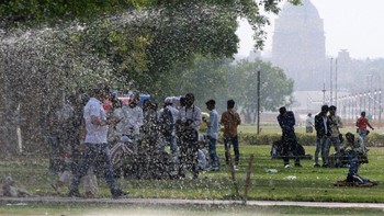 Orang-orang melintas di dekat pancaran air di gerbang India Gate, di bawah sinar matahari yang terik dan gelombang panas sore hari, pada 15 April 2023 di New Delhi, India. Gelombang panas menjadi lebih sering dan lebih intens seiring dengan meningkatnya suhu global akibat perubahan iklim yang didorong oleh manusia, yang sebagian besar disebabkan oleh pembakaran bahan bakar fosil. Foto: Getty Images