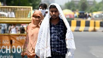 Masih di Kolkata, seorang pria menyelimuti kepalanya dengan handuk. Panas telah merenggut korban jiwa di India. Setidaknya 13 orang dilaporkan tewas akibat sengatan panas setelah menghadiri acara yang diselenggarakan pemerintah di lapangan terbuka tanpa tempat berlindung akhir pekan lalu. Foto: Getty Images