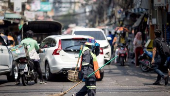 Seorang petugas kebersihan di Bangkok melindungi seluruh tubuhnya agar tak kena sinar Matahari langsung. Suhu mencapai 44,6 derajat Celcius di provinsi barat Tak, suhu terpanas yang pernah tercatat di negara itu. Foto: Getty Images