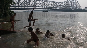 Para anak laki-laki di India melompat ke Sungai Gangga di depan Jembatan Howrah pada hari yang panas di Kolkata, India. Suhu tinggi lebih berbahaya diperkirakan terjadi beberapa bulan mendatang. Peristiwa El Nino yang akan segera terjadi, selain perubahan iklim yang disebabkan oleh manusia, dapat mencatat rekor panas baru pada musim panas ini dan berikutnya, para peramal telah memperingatkan. Foto: Getty Images