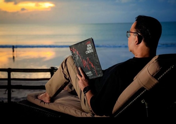 Anies Baswedan unggah foto baca buku di pinggir laut.