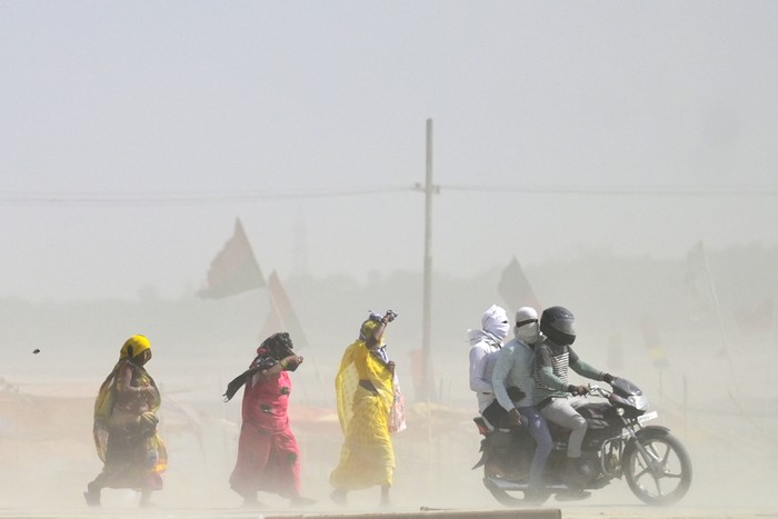 People walk through a dust storm on a hot summer day in Prayagraj on April 18, 2023. (Photo by Sanjay KANOJIA / AFP) (Photo by SANJAY KANOJIA/AFP via Getty Images)