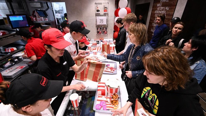 Visitors receive their orders in the Russian version of a former KFC's restaurant, now Rostic's during the opening ceremony in Moscow on April 25, 2023. - The Russian incarnation of KFC opened its first restaurant in Moscow on April 25, 2023 after the American fast food chain exited the country over the Kremlin's offensives in Ukraine. (Photo by Kirill KUDRYAVTSEV / AFP) (Photo by KIRILL KUDRYAVTSEV/AFP via Getty Images)