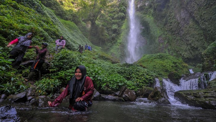 Sejumlah pengunjung menaiki tebing Air Terjun Pancuran Rayo di Pulau Tengah, Kerinci, Jambi, Selasa (25/4/2023). Air terjun dengan ketinggian 150 meter di dalam kawasan Taman Nasional Kerinci Seblat (TNKS) itu menjadi salah satu pilihan warga untuk menikmati libur Lebaran 1444 H. ANTARA FOTO/Wahdi Septiawan/YU