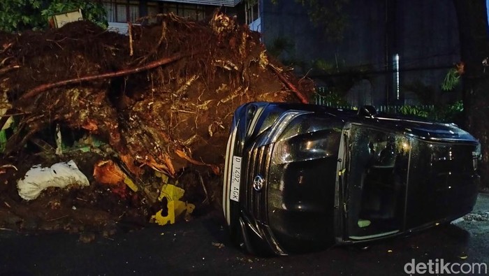 Mobil terbalik akibat pohon tumbang di Dago, Kota Bandung, rabu (26/4/2023).