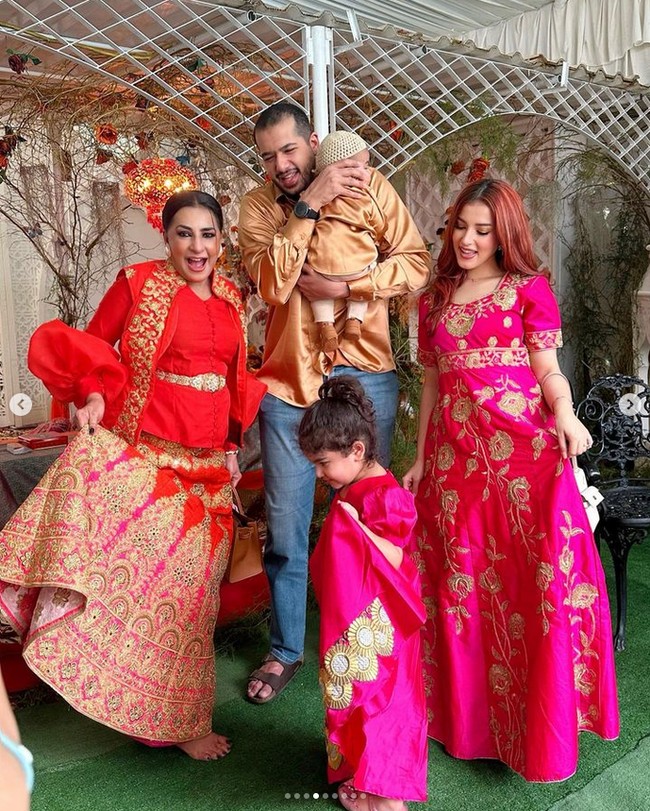Tasya memakai dress panjang berwarna fuschia dengan bordiran emas motif bunga seperti putrinya. Sang suami Ahmad Assegaf memakai kemeja berwarna gold yang senada bersama putranya. Sedangkan ibunya memakai busana berwarna merah yang tak kalah mewah. Foto: Instagram