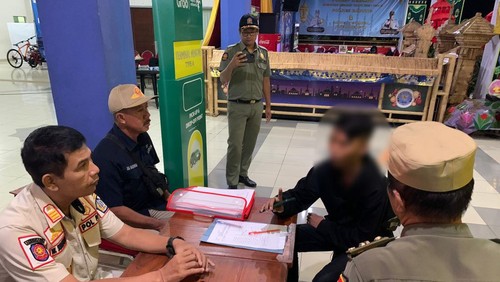 Petugas Satpol PP Badung menginterogasi seorang penumpang bus tanpa identitas di Terminal Mengwi, Rabu (26/4/2023).