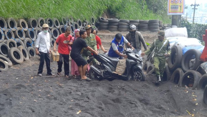Relawan membantu pengendara yang nyaris celaka di jalur Klemuk Kota Batu