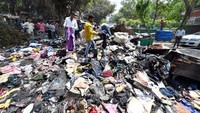 Penampakan ratusan pakaian yang terbakar dan terdampar di pinggir jalan.