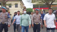 AKBP Achiruddin dikawan personel dari Propam saat akan menuju ruang pemeriksaan. (Finta Rahyuni/detikSumut)