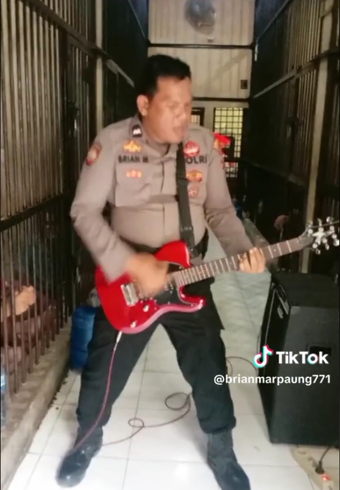 Aksi polisi memainkan gitar sambil melantunkan lagu Elang milik Dewa 19 untuk menghibur tahanan viral di medsos. Aksinya itu pun menuai pujian dari netizen. (TikTok @brianmarpaung771)