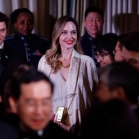 Angelina Jolie sendiri tampil elegan dengan busana serba putih. Dia memakai dress putih yang dipadukan dengan jaket vintage Chanel. Jaket tersebut dibuat khusus untuknya beberapa tahun lalu. Foto: Getty Images
