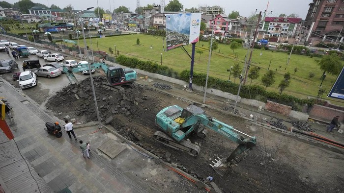 An earthmover repairs s road ahead of the G20 Tourism Working Group meeting in Srinagar, Indian controlled Kashmir, Wednesday, April 26, 2023. India is to host its third G20 Tourism Working Group meeting in Srinagar between May 22 and 24. (AP Photo/Mukhtar Khan)