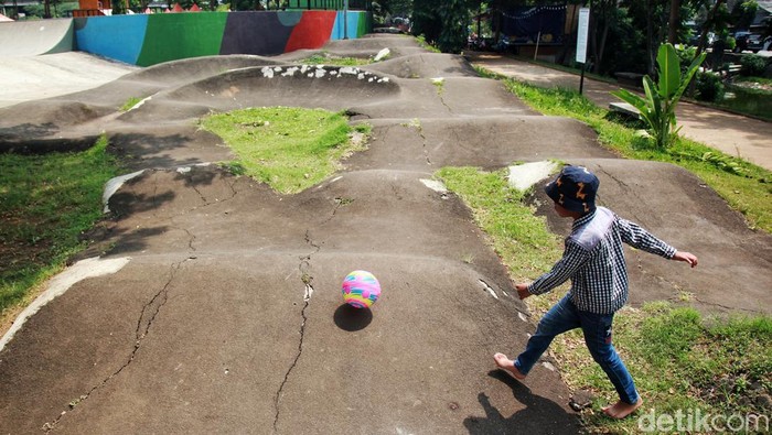 Anak-anak bermain di taman skatepark dan BMX track di RPTRA Kalijodo, Jakarta, Kamis (27/4/2023). Tampak pagar seng memberi batas dengan pengunjung pada tembok bangunan RPTRA yang mulai keropos di beberapa titik sehingga rawan roboh. Selain itu, cat mural sudah mulai memudar. Trek sepeda BMX retak ataupun mengelupas di beberapa lokasi. Bendera merah putih yang berkibar j7ga sudah usang dan robek di bagian putih bendera. Pemprov DKI Jakarta bakal menggelontorkan anggaran Rp 1,7 miliar untuk memperbaiki RPTRA kebanggaan Jakarta tersebut melalui Dinas Pertamanan dan Hutan Kota DKI, bulan depan.