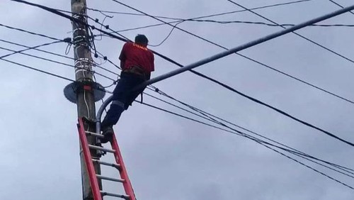 Petugas Dishub Karangasem melakukan perbaikan LPJU menggunakan tangga manual.