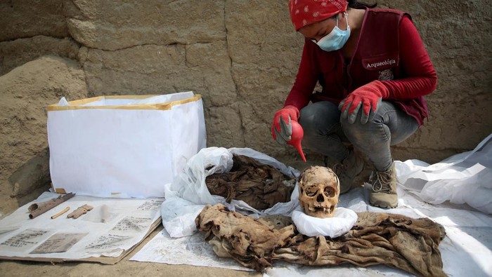 Mumi Masa Pra-Inca Ditemukan di Peru, Begini Penampakannya LIMA, PERU - APRIL 26: The skull and clothes of a mummy are displayed after being founded at Cajamarquilla archeological site, in the outskirts of the Peruvian capital on April 26, 2023 in Lima, Peru. The mummy is over 1000 years old and was found in an underground tomb wrapped in a funerary bundle and in a great state of conservation including bits of skin and hair. The adolescent probably belonged to the Lima or Ichma cultures. (Photo by Raul Sifuentes/Getty Images)