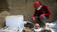 Seorang pekerja membersihkan sisa-sisa mumi di situs arkeologi Cajamarquilla, di pinggiran ibu kota Peru pada 26 April 2023 di Lima, Peru. Raul Sifuentes/Getty Images
