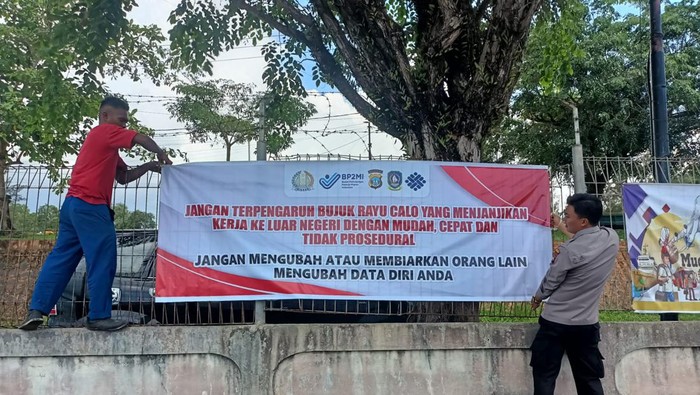 Sejumlah petugas kepolisian melakukan pemasangan spanduk sosialisasi di Pelabuhan Internasional Batam.(dok Polda Kepri)