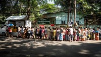Orang-orang berbaris untuk menerima minyak goreng gratis di jalanan Yangon, Myanmar, Selasa (25/4/2023).  