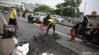 Petugas Bina Marga melakukan perbaikan jalan berlubang di Jalan KH Abdullah Syafei, Jakarta, Jumat (28/4/2023).  