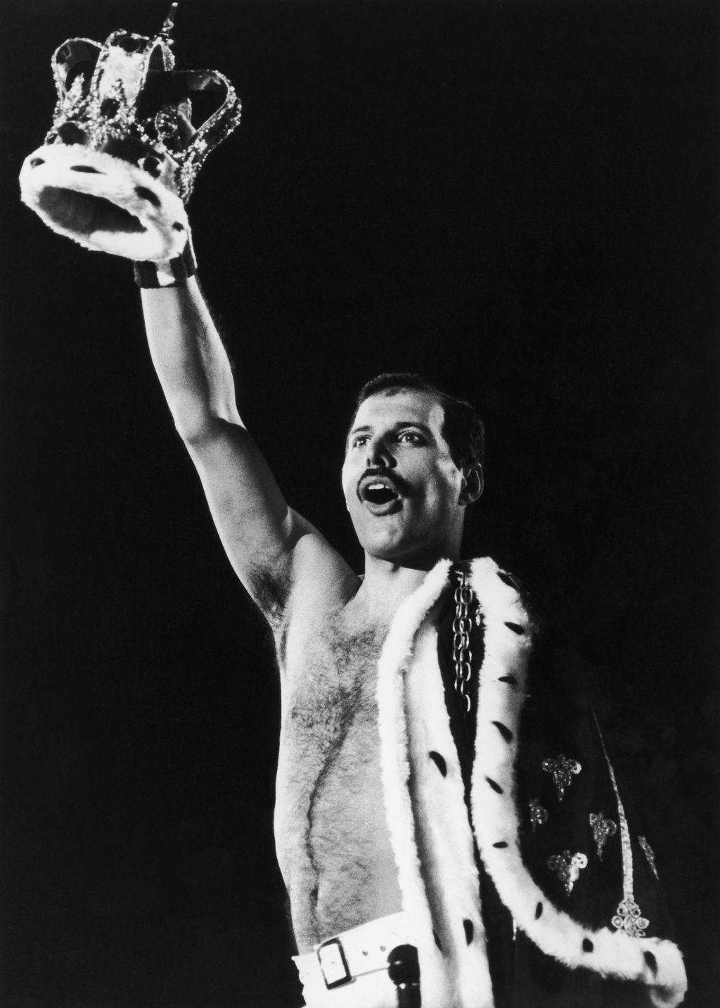 A regally attired Freddie Mercury (1946 - 1991), of British rock group Queen, raises a crown during a performance, 1986. (Photo by Dave Hogan/Hulton Archive/Getty Images)