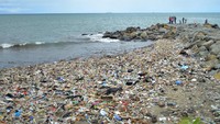 Pengunjung berwisata di dekat tumpukan sampah di Pantai Padang, Sumatera Barat, Jumat (28/4/2023).   