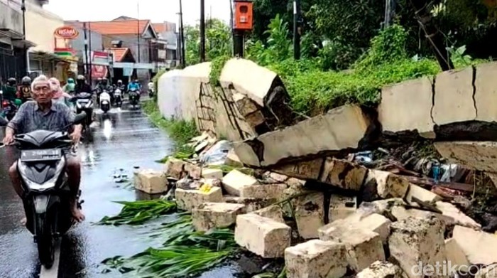 Motor matik milik warga yang tertimpa tembok penahan tanggul yang ambrol Motor matik milik warga yang tertimpa tembok penahan tanggul yang ambrol
