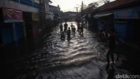 Anak-anak memanfaatkan banjir ini untuk bermain.