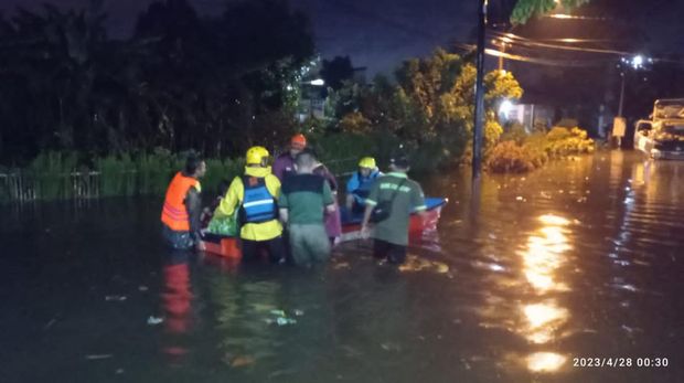 Relawan mengevakuasi lansia yang rumahnya terdampak banjir di wilayah perkotaan Kabupaten Cilacap, Kamis (27/4/2023) malam.