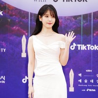 Penyanyi dan aktris IU memakai gaun satin warna ivory dari koleksi busana pengantin Katherine Tash. Foto: Twitter/@TikTok_Korea, Instagram/@koreadispatch