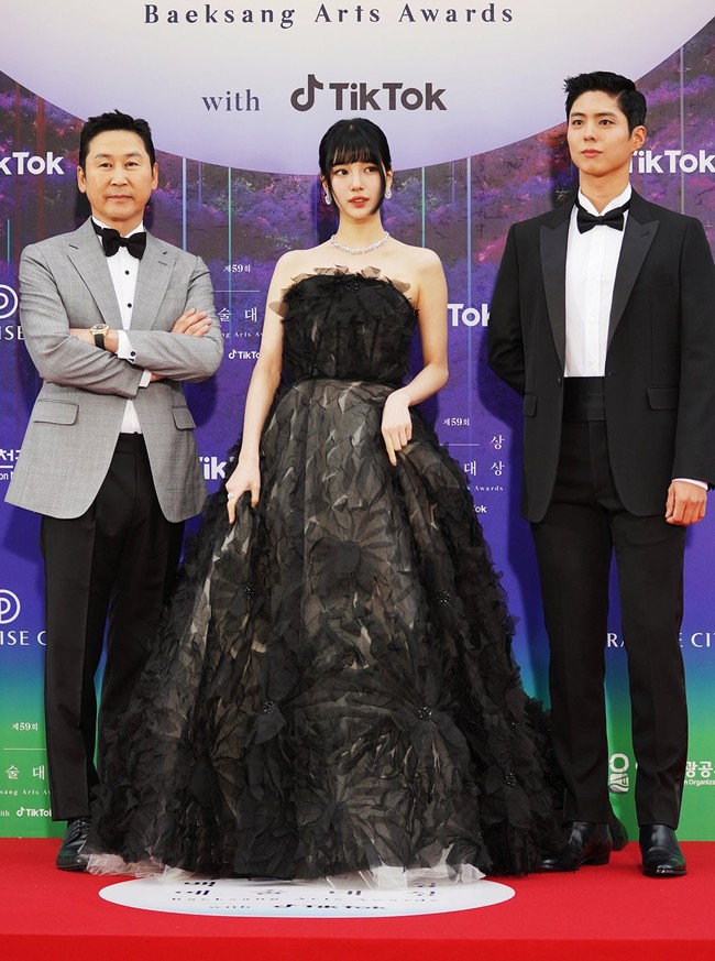 Bae Suzy tampil mencuri perhatian dengan kecantikannya yang dipuji bak seorang putri. Gaun hitam dari koleksi busana pengantin Marco y Maria menonjolkan kesan dramatis dengan aplikasi tiga dimensi bentuk bunga. Suzy melengkapi penampilannya dengan kalung berlian berkilauan yang mengaksentuasi lehernya. Foto: Twitter/@TikTok_Korea, Instagram/@koreadispatch