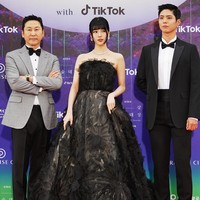 Bae Suzy tampil mencuri perhatian dengan kecantikannya yang dipuji bak seorang putri. Gaun hitam dari koleksi busana pengantin Marco y Maria menonjolkan kesan dramatis dengan aplikasi tiga dimensi bentuk bunga. Suzy melengkapi penampilannya dengan kalung berlian berkilauan yang mengaksentuasi lehernya. Foto: Twitter/@TikTok_Korea, Instagram/@koreadispatch