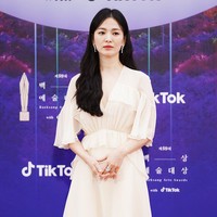 Salah satu aktris yang ditunggu-tunggu di Baeksang Awards, Song Hye Kyo, tampil dengan gaun chiffon pink. Gaun berpotongan A-line itu dirancang dengan garis leher rendah, dan dipercantik detail ruffle pada lengan dan pinggang. Bintang utama ‘The Glory’ ini memilih riasan wajah minimalis bernuansa nude-pink. Foto: Twitter/@TikTok_Korea, Instagram/@koreadispatch
