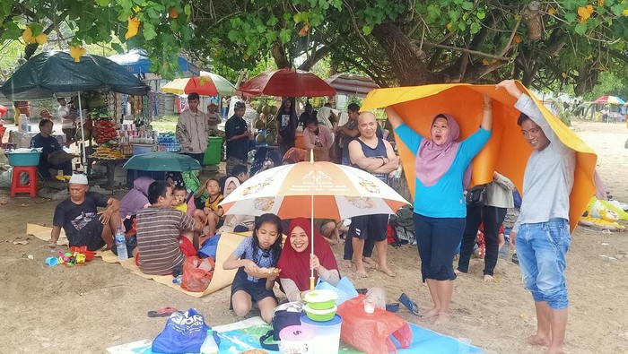 Beberapa warga yang merayakan Lebaran Ketupat tampak berteduh di Pantai Sanur, Denpasar, Bali pada Sabtu (29/4/2023)