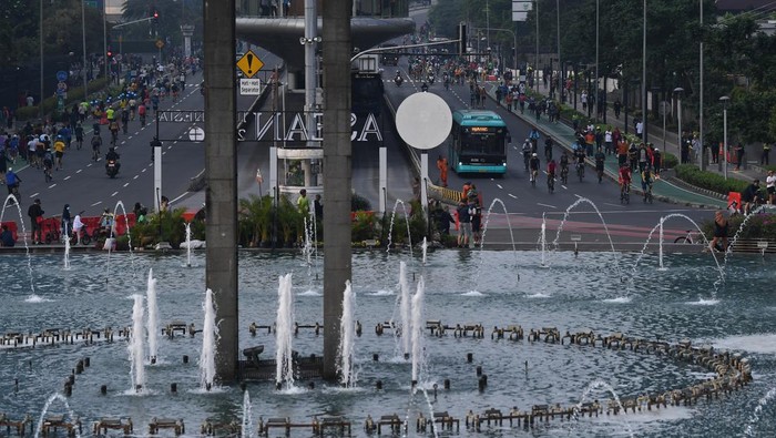 Warga dan sejumlah kendaraan bermotor melintas di Bundaran HI, Jakarta, Minggu (30/4/2023). Meski Pemprov DKI Jakarta masih meniadakan hari bebas kendaraan bermotor di Ibu Kota pada 30 April 2023 karena momen Lebaran 2023, namun sejumlah warga terpantau masih beraktivitas dan berolahraga di ruas Jalan MH Thamrin dan Jalan Jenderal Sudirman, Jakarta. ANTARA FOTO/Sigid Kurniawan/foc.
