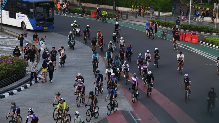 Warga dan sejumlah kendaraan bermotor melintas di Bundaran HI, Jakarta, Minggu (30/4/2023). Meski Pemprov DKI Jakarta masih meniadakan hari bebas kendaraan bermotor di Ibu Kota pada 30 April 2023 karena momen Lebaran 2023, namun sejumlah warga terpantau masih beraktivitas dan berolahraga di ruas Jalan MH Thamrin dan Jalan Jenderal Sudirman, Jakarta. ANTARA FOTO/Sigid Kurniawan/foc.