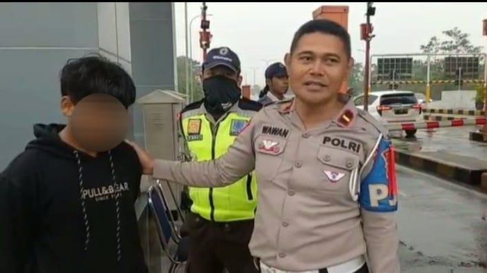 Ipda Wawan saat bersama bocah yang tersesat di Tol Singosari Malang