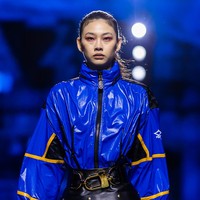 Atasan berupa jaket oversized dalam warna biru elektrik yang mencuri perhatian menjadi andalan. Sementara itu, rok kulit high-waist bersiluet A dengan detail stud dan sabuk besar hadir sebagai bawahan. (Foto: Justin Shin/Getty Images)