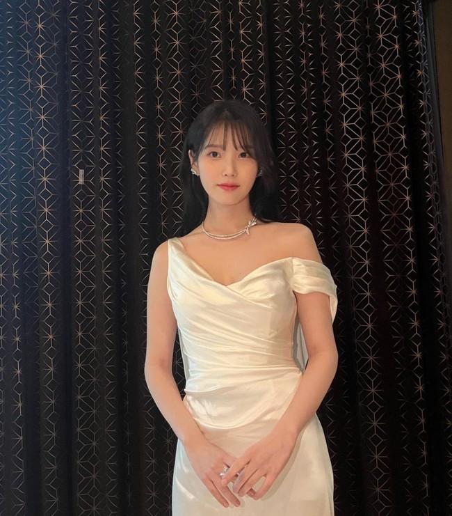 Simpel dan minimalis, gaun pengantin yang dikenakan IU tetap memancarkan aura feminin dengan garis leher asimetris. Foto: Instagram/@dlwlrma