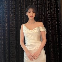 Simpel dan minimalis, gaun pengantin yang dikenakan IU tetap memancarkan aura feminin dengan garis leher asimetris. Foto: Instagram/@dlwlrma