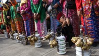 Sejumlah warga membawa rantang makanan saat mengikuti Lebaran Kukusan di Kawasan Kukusan, Depok, Jawa Barat, Minggu (30/4/2023).