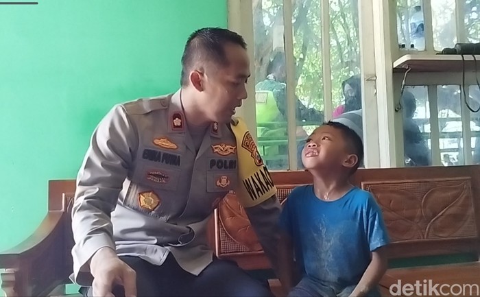 Wakapolres Gresik Kompol Erika saat menghibur anak yang kehilangan ibunya di Pantai Delegan